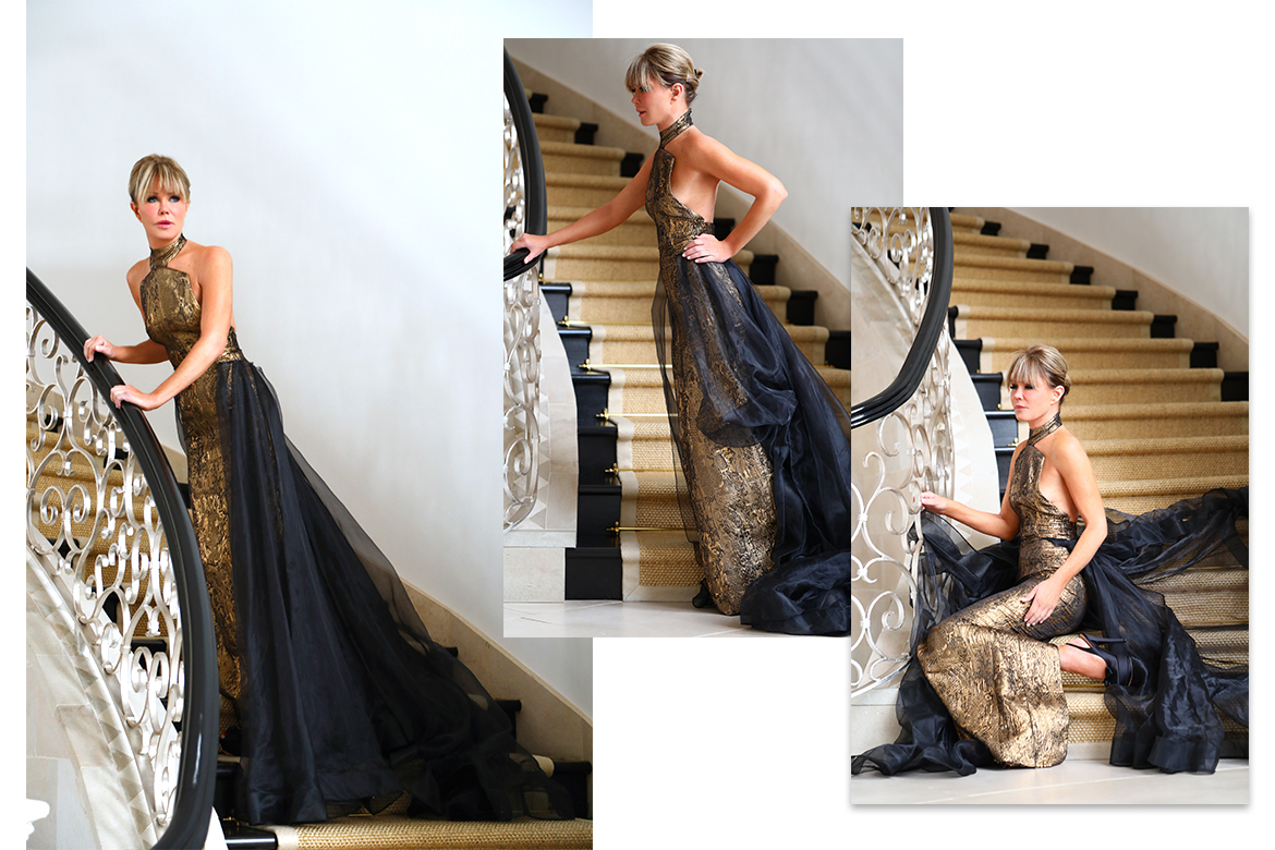 Laura dunn on a staircase wearing a luxurious stello gown by Michael costello